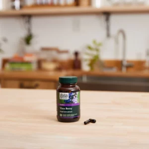 A supplement bottle containing Vitex Berry capsules placed on a table.